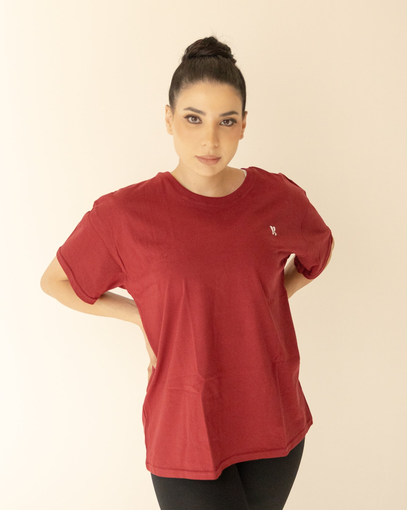 Woman wearing a red t-shirt on a beige background